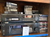 Shelf with Pioneer multi CD player, Sony audio/video control center, and stacks of CDs