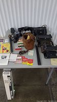 Full lot on table showing Canon camera, tripods, flash bulbs and accessories