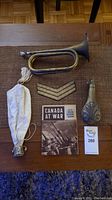Full view of lot items including bugle, patch, powder horn, booklet, and purse