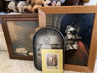 Photo showing four framed art and photo pieces: a signed Jody Bergsma print, a craftsman warrior portrait, a sepia-toned still life, a vintage baby photo, and an animal card.