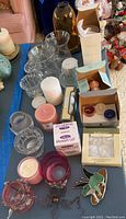 Photo showing assortment of candles, glass holders, packaging, frog clip, and Museum Gel on blue table