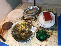 Overall view of the lot showing decorative plates, bowls, and serving dishes with varied designs and materials.