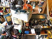 Overview photo showing a cluttered array of tools including a white plastic basket with items, Kal-Lite drill bit sharpener, steel wool pads, cutting tools, and rulers.