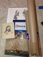 Collection of unframed art prints laid out on carpet including zebra print, penguins, a group scene, a pencil portrait, and a detailed ship print; also a mailing tube is included.