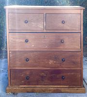 Front view of a 5 drawer mesquite wood chest showing wear and scratches on front panels.