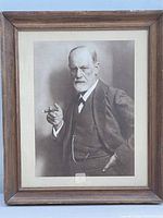 Front view of framed photo print of Sigmund Freud showing a black and white image of Freud holding a cigar, framed in wood with visible matting and detail.