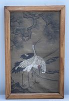Full view of framed Japanese ink painting showing two white cranes standing under pine tree branches in a wooden frame.