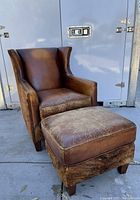 Front angle view of brown leather club chair and matching ottoman