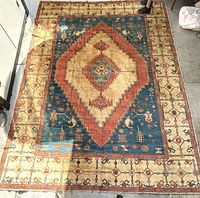 Full view of the oriental rug showing central diamond medallion, multiple borders, and color scheme.