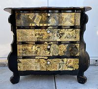 Front view showing four drawers with collage decoupage of classical prints and figures, some paper missing and worn edges.