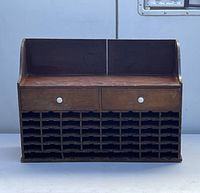 Front view showing two drawers with white knobs and multiple cubby holes.