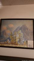 Framed painting depicting a mountain with floral foreground, signed Thos. L. Lewis - Taos.