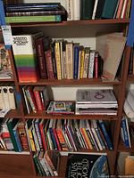 Photo of five shelves filled with books including reference, dictionaries, and anthologies.