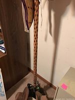 Full view of the wooden carved coat rack in a corner with some hats hanging