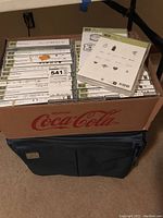 Box of Stampin UP craft stamp sets in white plastic cases stacked horizontally, some sets visible with titles and logos.