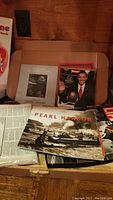 Photo shows various historical magazines including TIME's bicentennial issue with George Washington, Newsweek with Barack Obama, and Life. Also visible are a National Geographic Pearl Harbor book and an Ansel Adams softcover book.