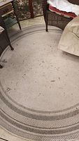 Full view of round rug on deck floor showing overall pattern and dirt condition.