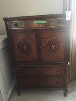 Front view of hand painted wood armoire with closed doors and drawers