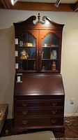 Front view of wooden secretary desk with hutch and three drawers