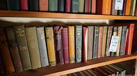 Shelf of vintage hardcover books showing various titles and signs of wear