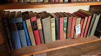 Shelf of assorted vintage hardcover books including classic literature and poetry.
