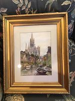 Photo of full framed print showing the ornate gold frame and matting around the print, clear view of the scene.