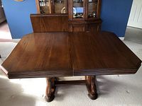 Full view of the wooden dining table showing the medium brown finish and rectangular top with beveled edges.