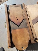 Close-up view of the top widowed wooden panel showing the metal triangular cutting blade.