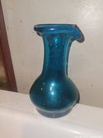 Photo of the aqua blue glass cruet decanter standing upright showing its full shape and color.