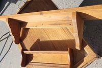 Longer solid pine shelf showing ornate side brackets and natural wood grain on light brown wood.
