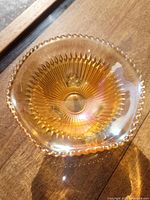 Top-down view of iridescent marigold carnival glass candy dish showing ruffled edges and bead detail around rim.