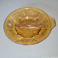 Top side view of vintage Indiana Glass Killarney iridescent carnival glass divided dish showing intricate scroll design and marigold rainbow colors with handle.