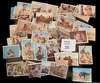 Top view of 45 color printed Rat Patrol cards spread out showing front images of characters, military vehicles and desert scenes from the TV series.