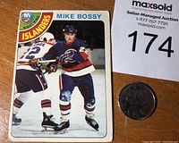 Front of 1978-79 O-Pee-Chee Mike Bossy rookie hockey card with player image and card number 115 alongside a coin for scale.