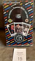 Front view of sealed wax box featuring NHL Original Six vintage player card images and colorful team city name background.