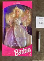 Front view of the unopened 1993 Sears Limited Edition Enchanted Princess Barbie doll in original box alongside a Sharpie marker for scale. Doll has long blonde curly hair, shimmering silver and pink dress, crown, and scepter.