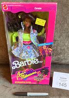 Front view of original unopened boxed Barbie & The Beat Christie doll with glow-in-the-dark costume and guitar accessory visible inside.