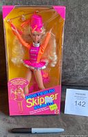 Front view of the unopened Skipper Majorette Doll in original box showing the doll in bright pink and orange majorette outfit, baton included, and packaging with colorful graphics.