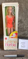 Frontal view of unopened Funtime Barbie in original box showing orange swimsuit through clear plastic window.