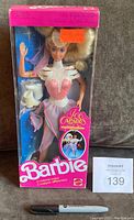 Front view of unopened Ice Capades Barbie in original box. Barbie dressed in pink and white skating costume, white skates included, pink box with Barbie and Ice Capades branding.