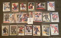 Top view of 25 autographed NHL cards laid out on a surface. Players visible include various teams and signatures in ink.