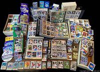 Overview of the lot including binders with multiple baseball cards, loose cards, boxes, wax packs, and other memorabilia spread on a table.