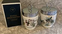 Two Royal Worcester porcelain egg coddlers and original box. One coddlers has a bird design, the other has a blackberry design.