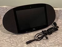 Front view of JBL Linkview with power cord, showing black oval form with fabric sides, 8-inch screen, and JBL logo