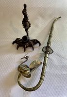 Photo showing both vintage pipes on a white fabric background, one with a bird claw base and the other with a swan figure.