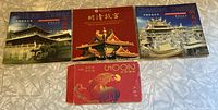 Four booklet cases and one red envelope featuring commemorative coins related to Chinese landmarks: Mikani Tower, Ming Palace, Chengtian Temple, and a separate red keepsake envelope.