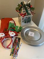 Lot overview showing centerpiece, charger plates, tree skirt, headbands and pencils