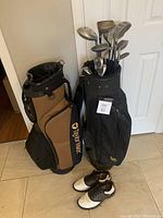 Two golf bags, one black with clubs and one brown TaylorMade brand, with a pair of white and black golf shoes in front