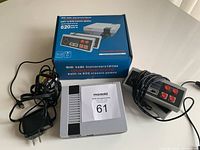 Full lot with mini game console, two wired controllers, power cord, and product box