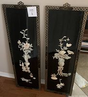 Front view of two rectangular lacquer wall panels featuring mother of pearl floral designs on black lacquer. Both panels have ornate borders and hanging hooks.